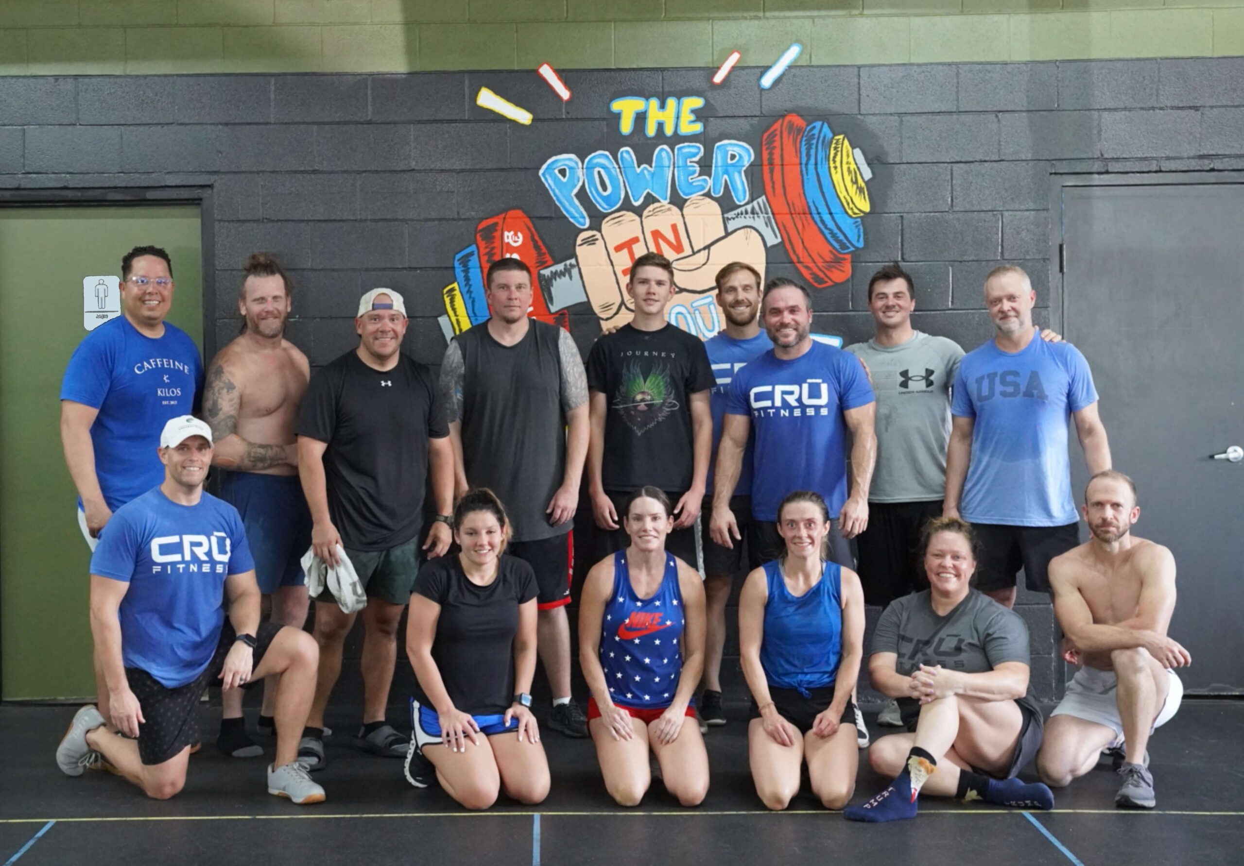 members and trainers of Crū Fitness gym in Ponchatoula, LA posing for a group picture after the July 4th, 2022 workout. They are posed in front of 'The Power In You' multi colored mural on gym wall.